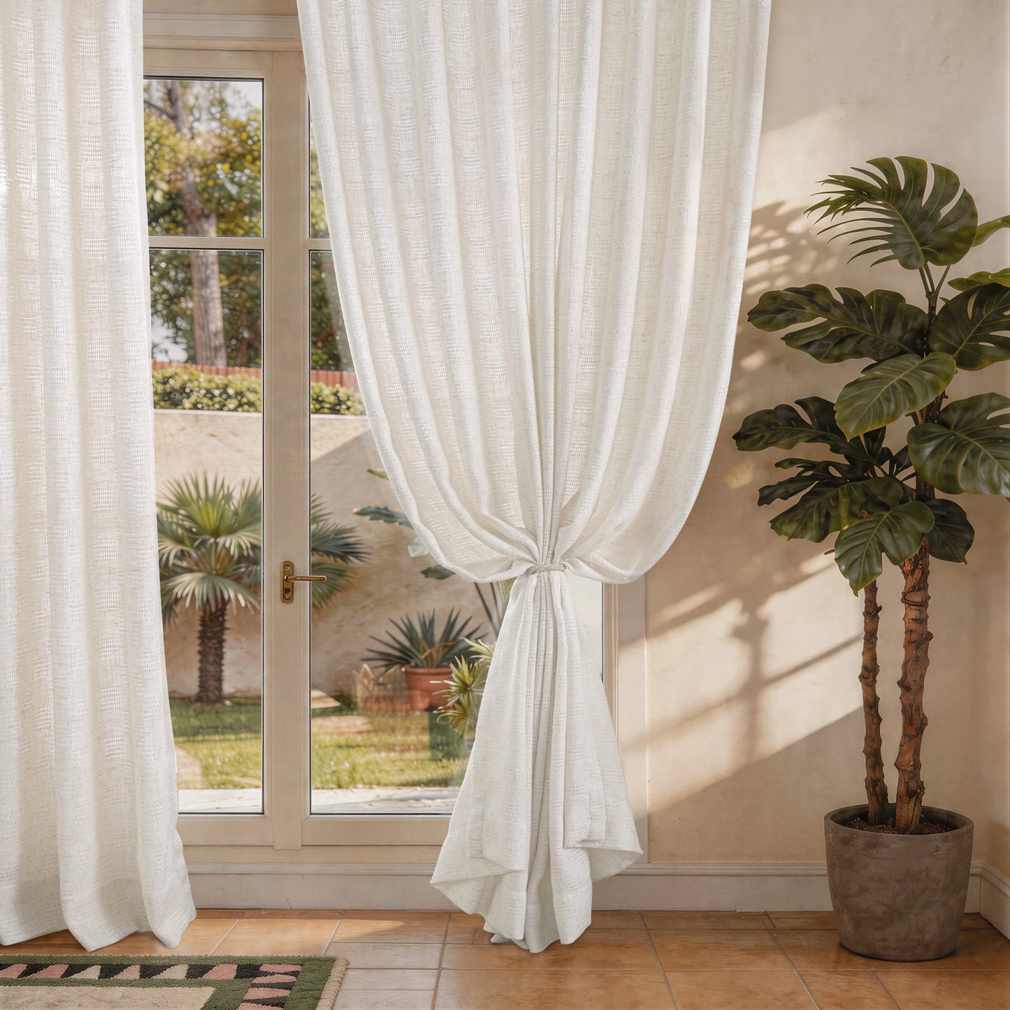 Airy open weave linen curtains tied back beside a window allowing soft natural light through