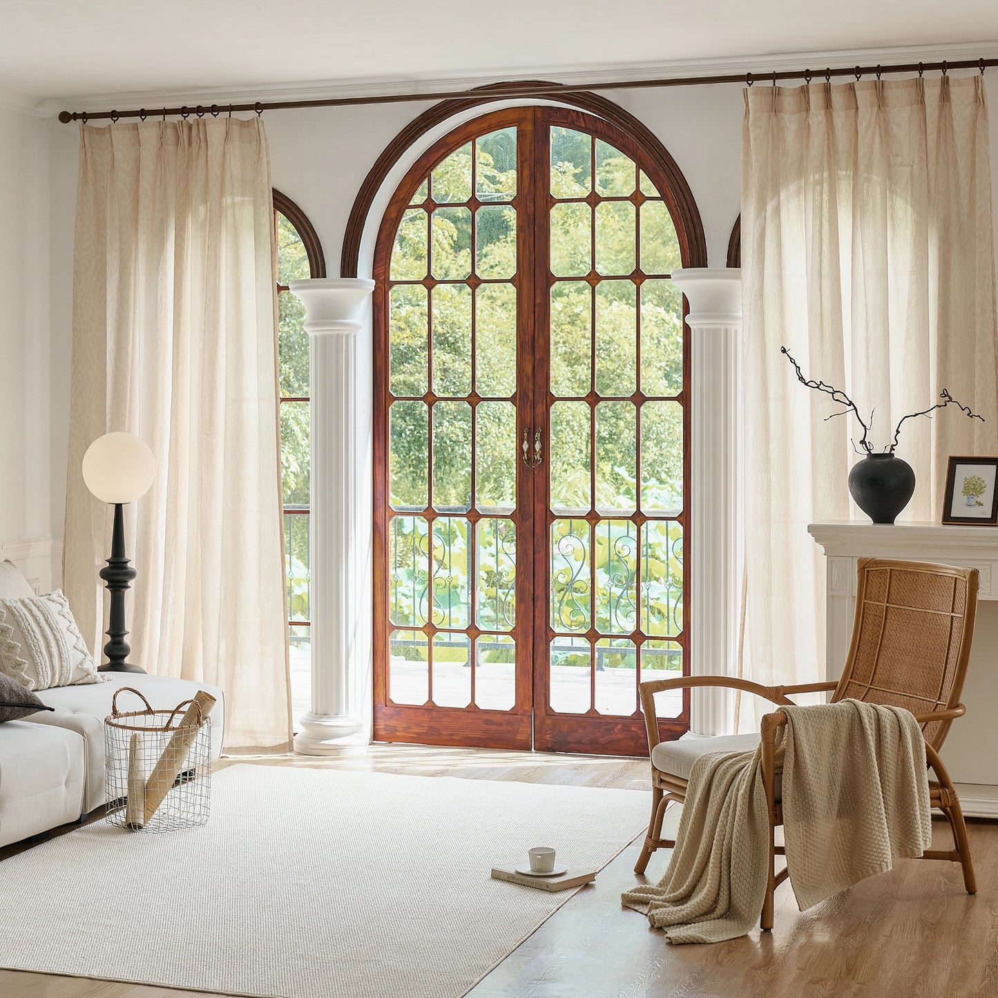 Neutral-beige wool gauze curtains with elegant raised botanical vine motif, in a room with plant and window view of trees.