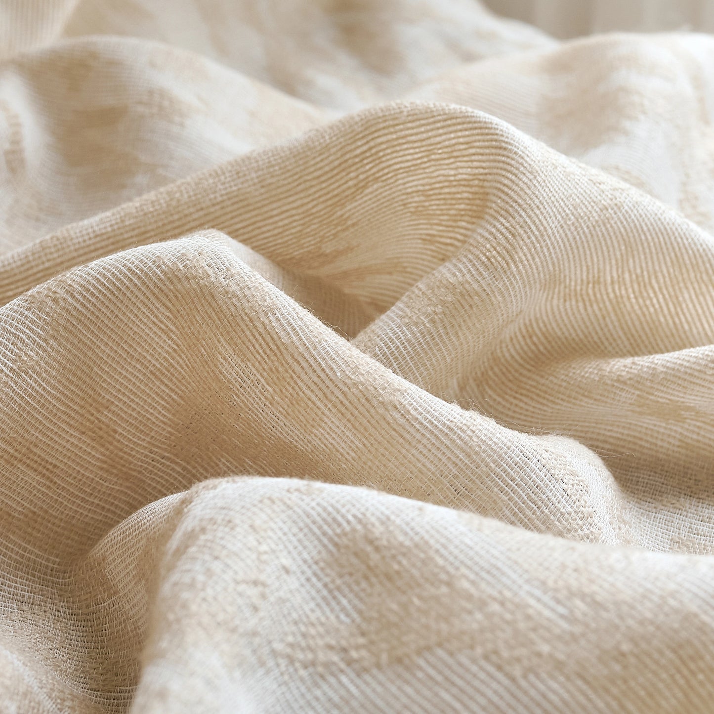 Beige wool gauze curtain with subtle leaf and vine embossed pattern, detailed view.