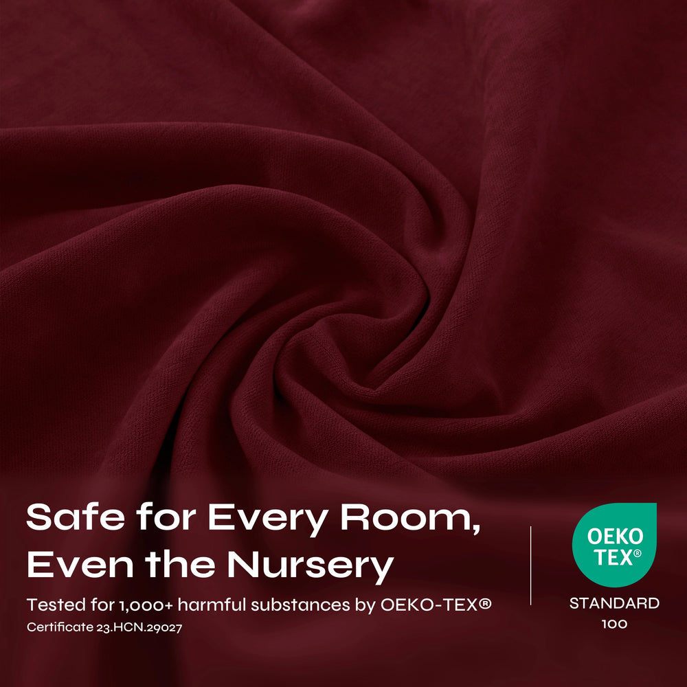A close-up of draped burgundy fabric with a soft, slightly velvety texture and gentle folds.