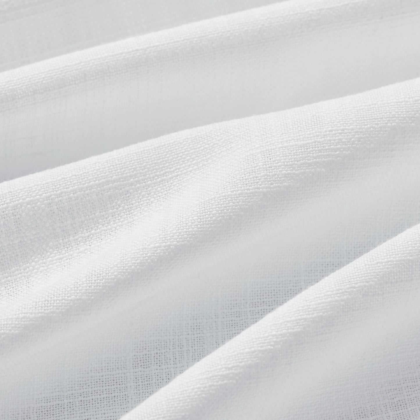 Detail of textured bleached ivory polyester-linen woven curtains.
