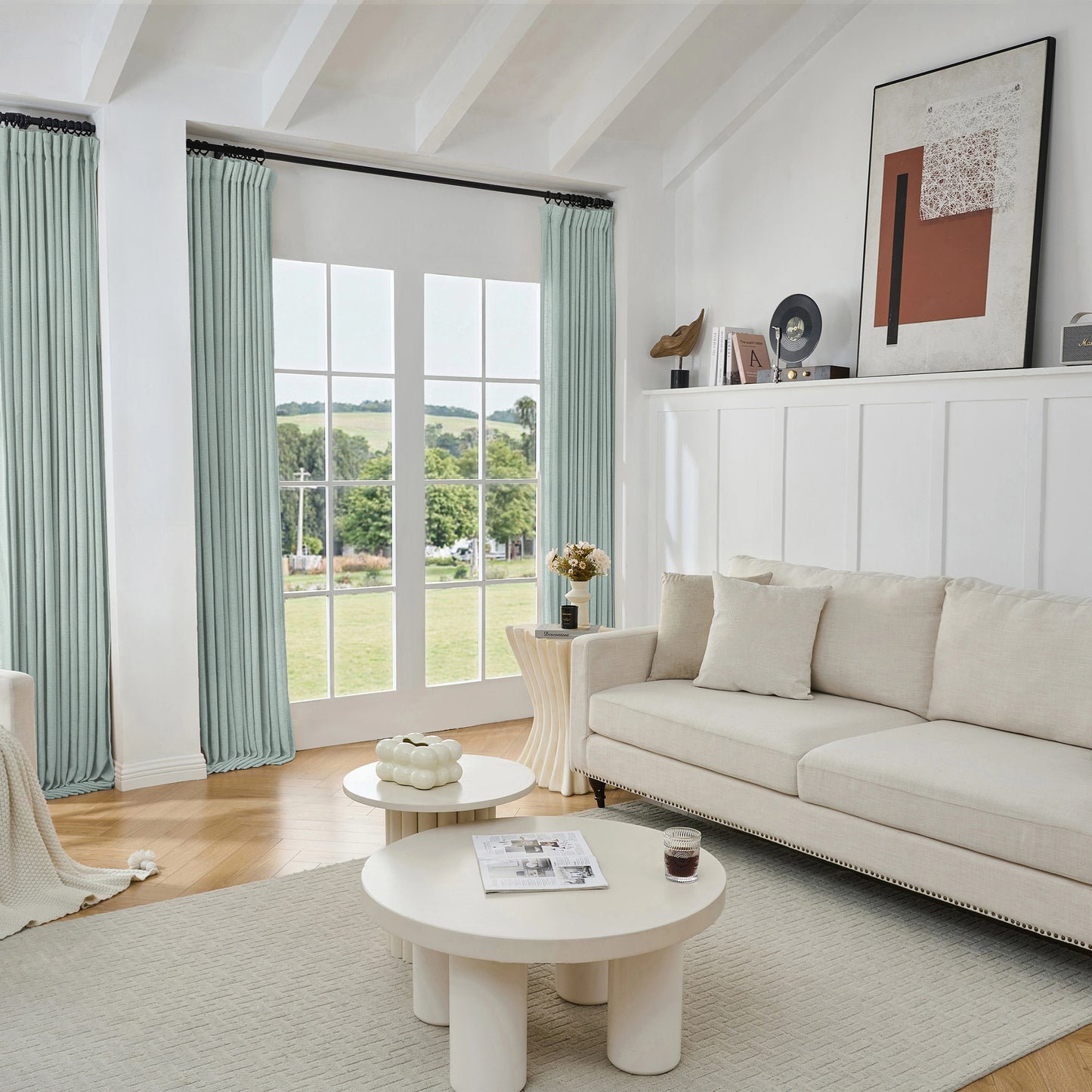 Living room with soft blue viscose, polyester, and linen mixed fabric curtain, white sofa, and tables.