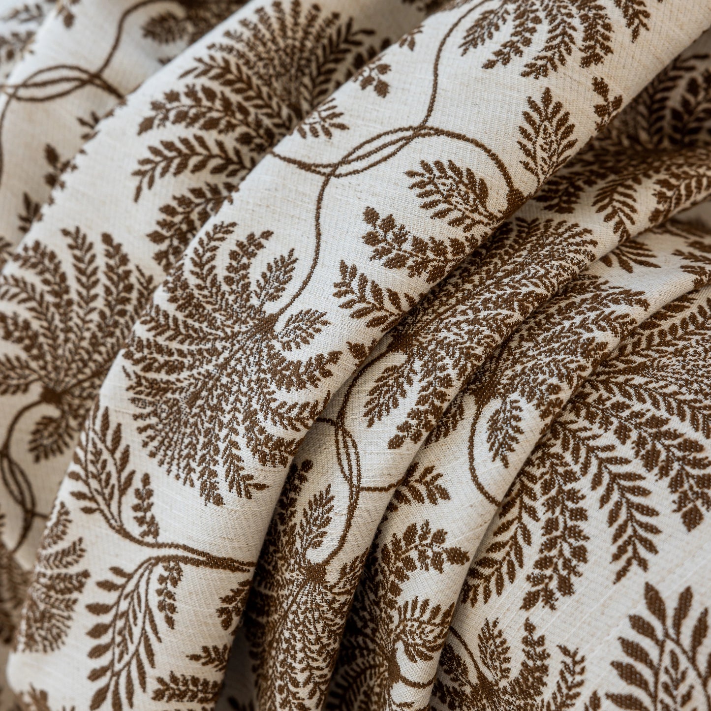 Close-up of coffee fern patterned boho fabric, detailed woven texture reflecting natural design with stylish elegance.
