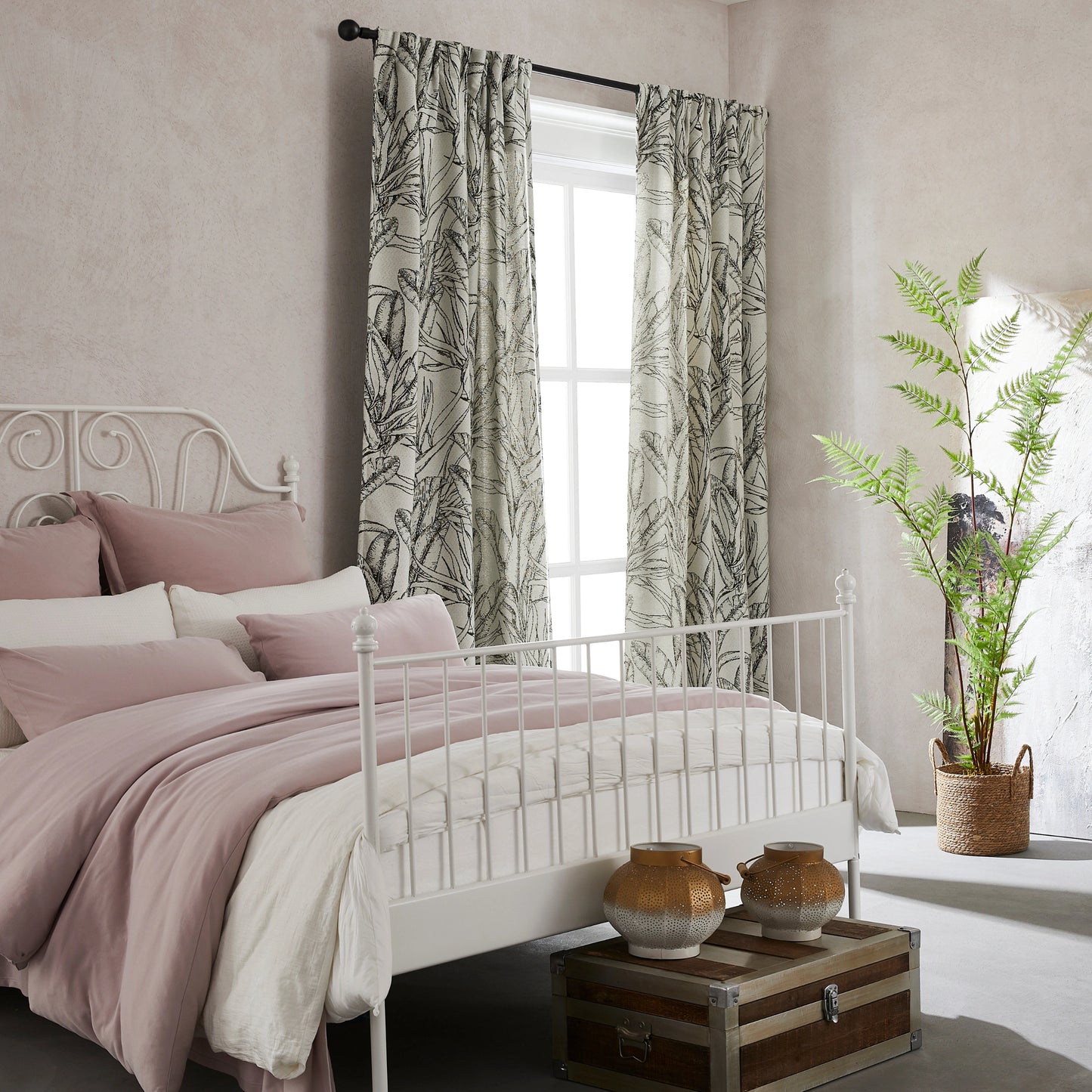 Boho-style drapes with botanical line art in verdant shades, with a bed and decorative items in the room.
