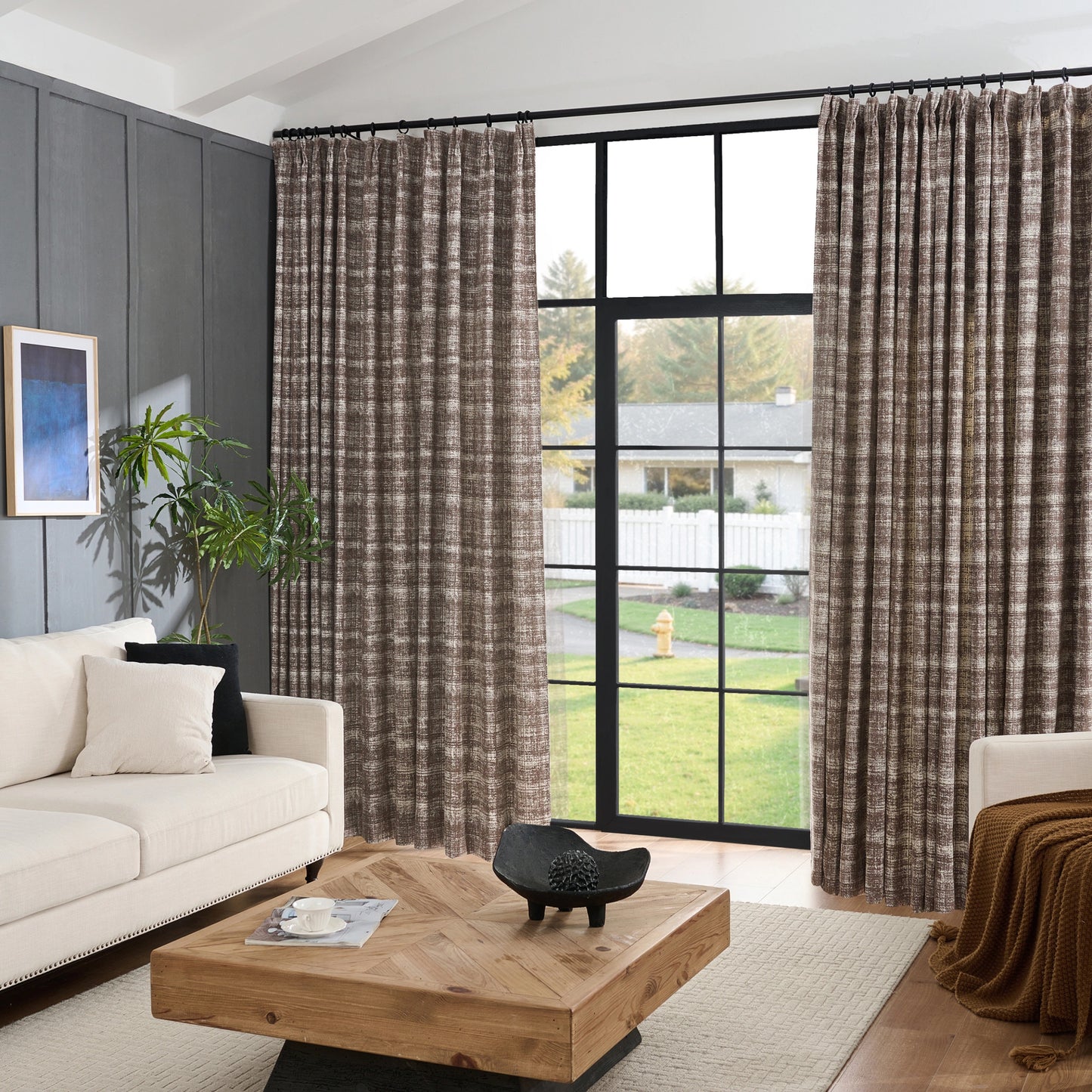Living room with sofa, wooden table, and large windows with chestnut modern curtain panel featuring abstract plaid pattern.