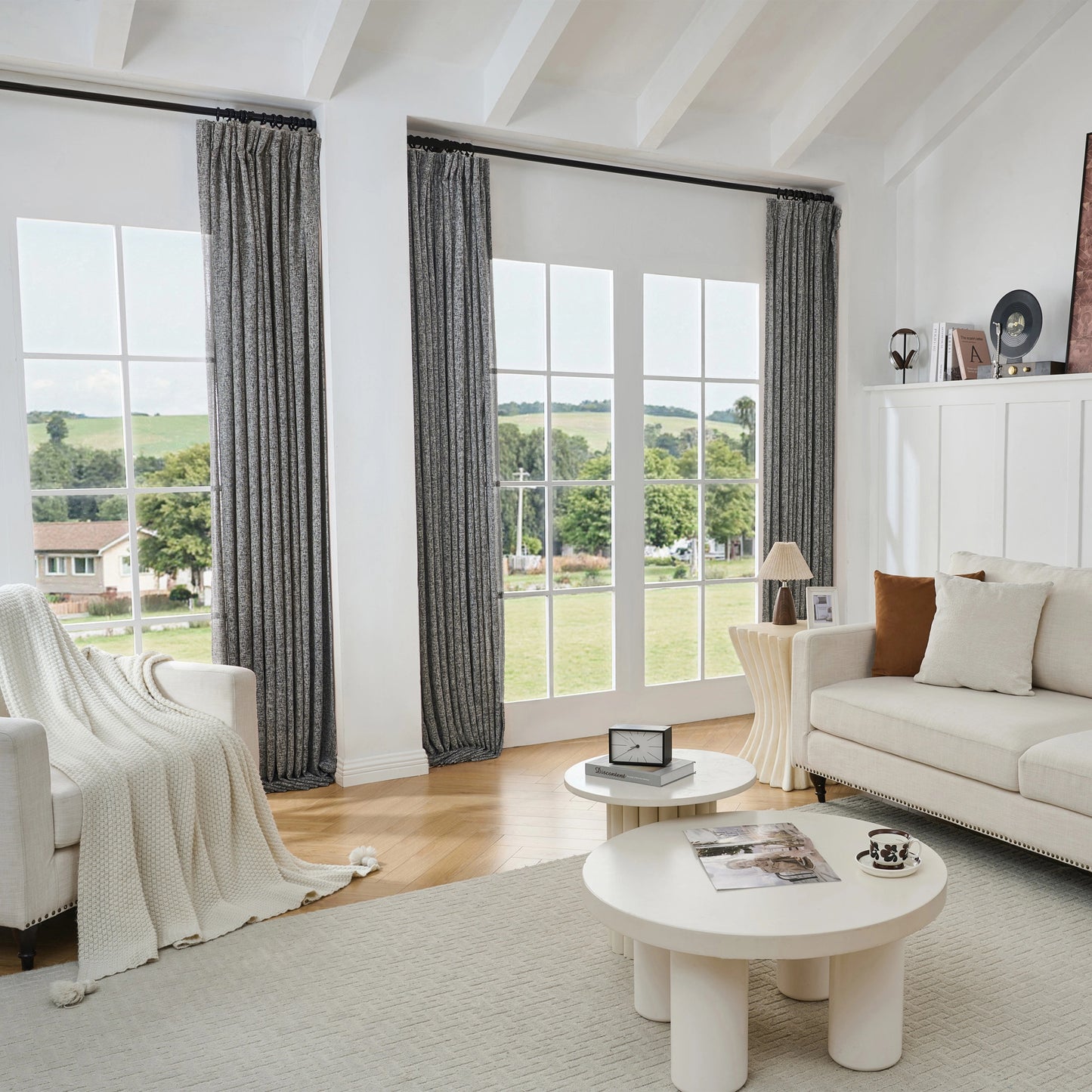 Living room with large windows, black and white poly-viscose-linen-drapery, and a white sofa.