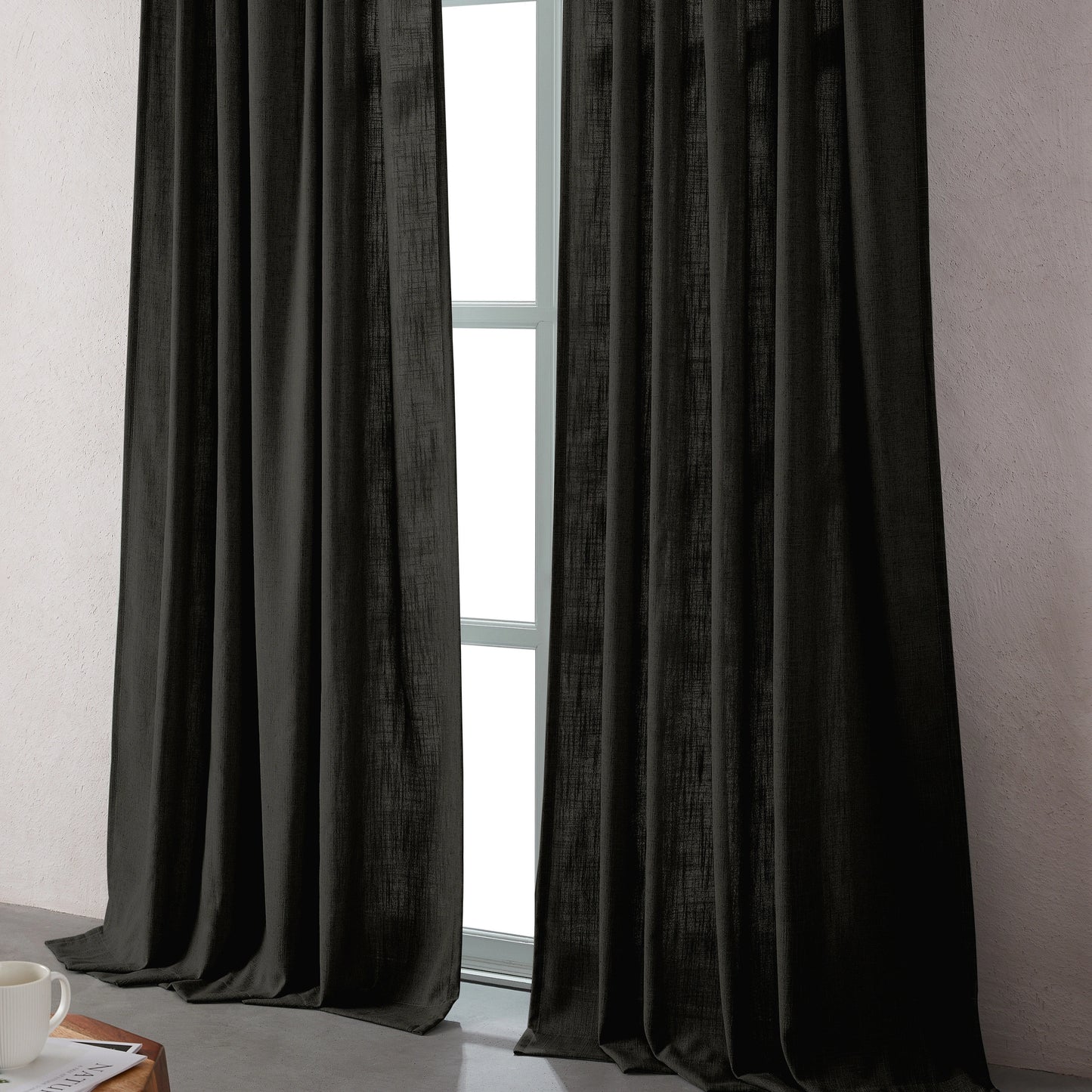 Dark gray linen-polyester blend curtains hanging in front of a window with a neutral background.