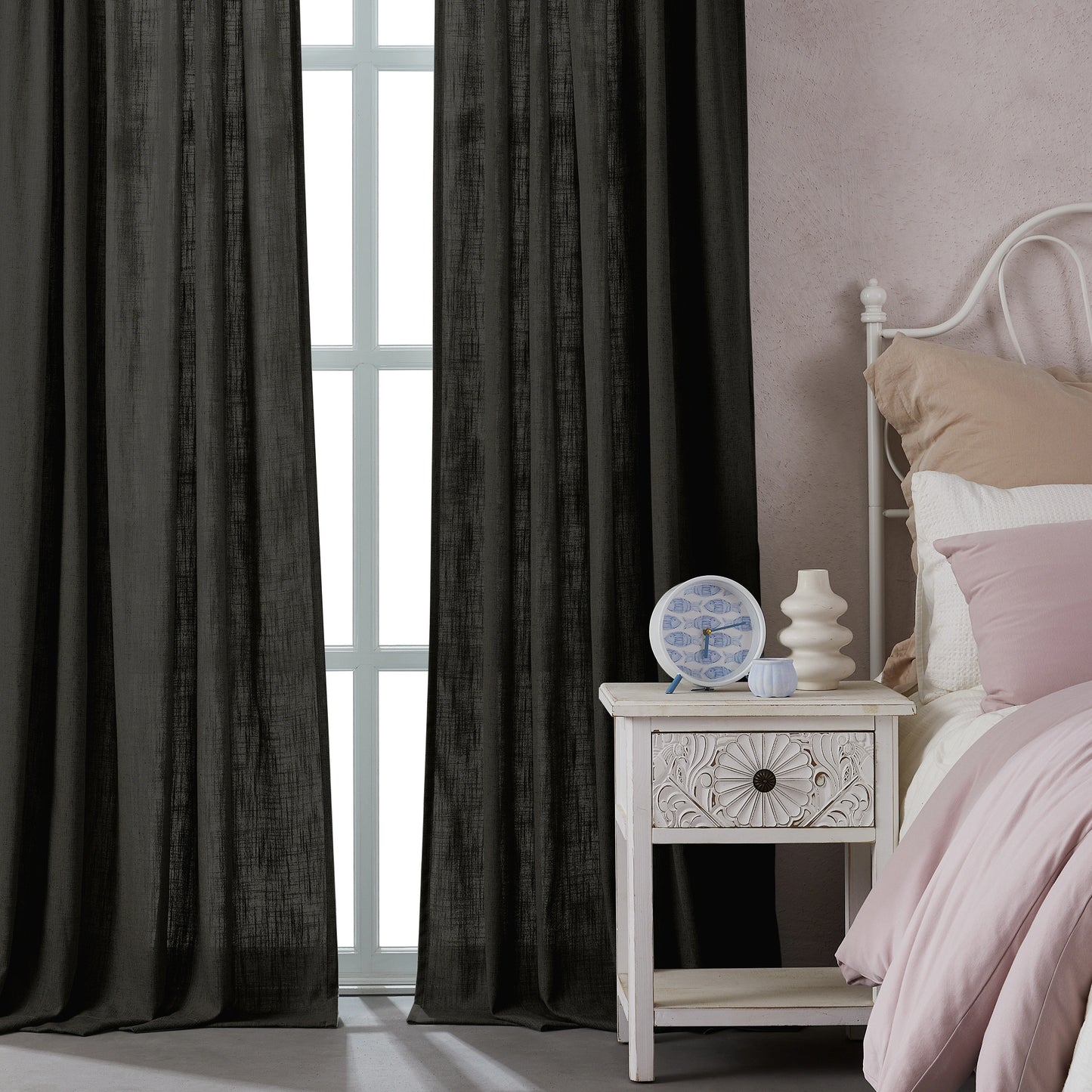 Bedroom with dark charcoal gray polyester-linen combination drapery panels, a nightstand, and a bed with pink bedding.