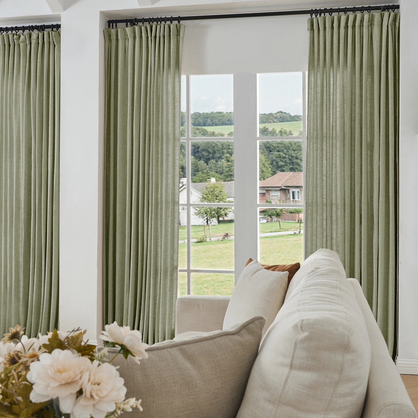Living room with slate gray curtains made of viscose, polyester, and linen, a sofa, and a view of greenery outside.