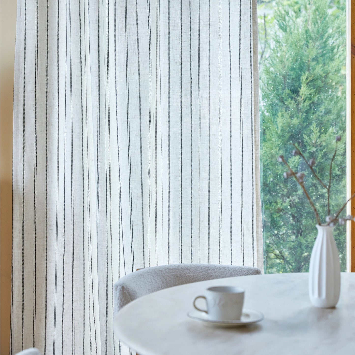 Close-up of farmhouse curtain fabric with irregular charcoal stripes, highlighting the linen texture.