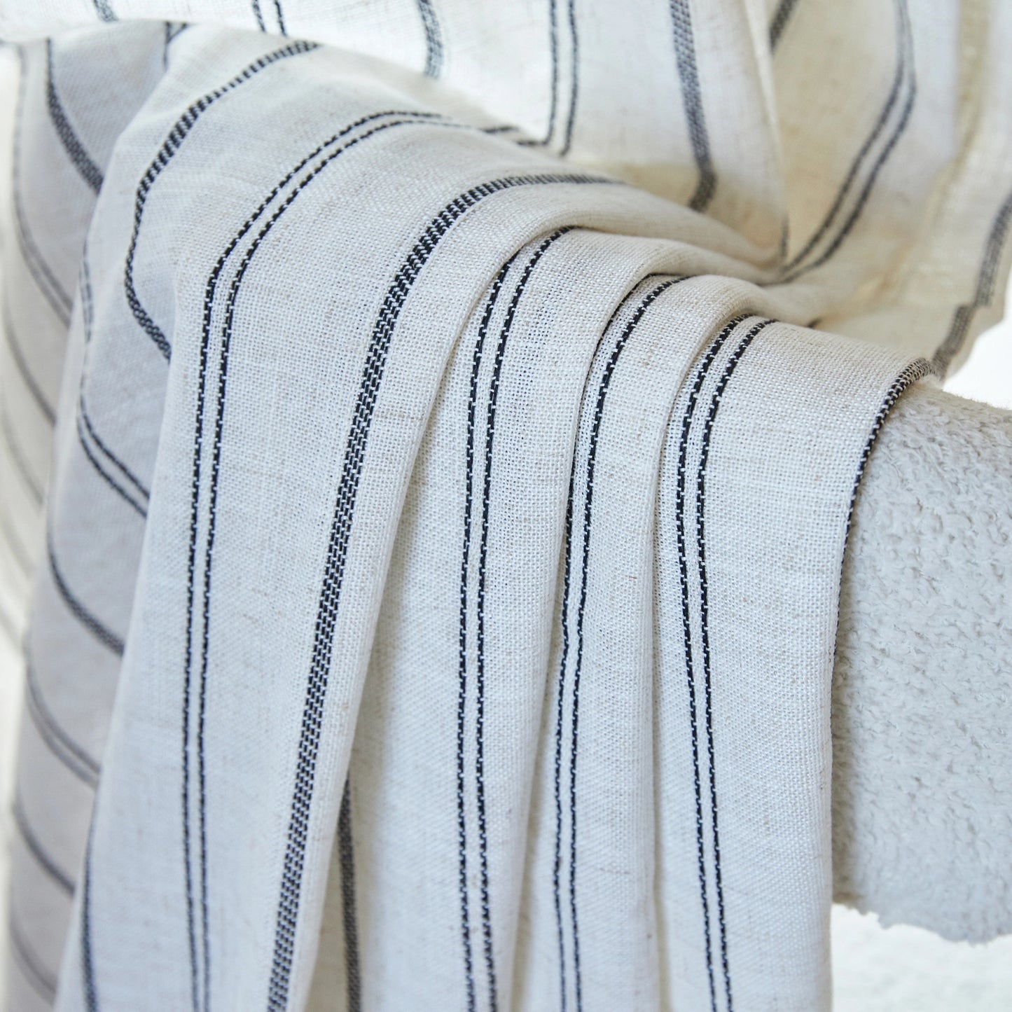 Detailed view of farmhouse drape with uneven line pattern, enhancing the texture of natural linen fabric.