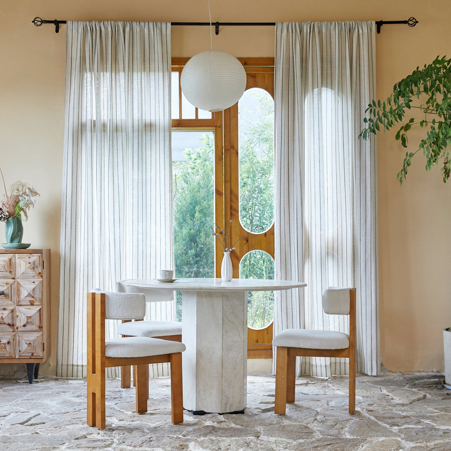 Dining room with table, chairs, and large windows dressed in farmhouse ivory curtains featuring uneven charcoal stripes.
