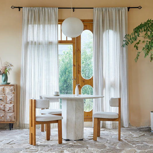 Dining room with table, chairs, and large windows dressed in farmhouse ivory curtains featuring uneven charcoal stripes.