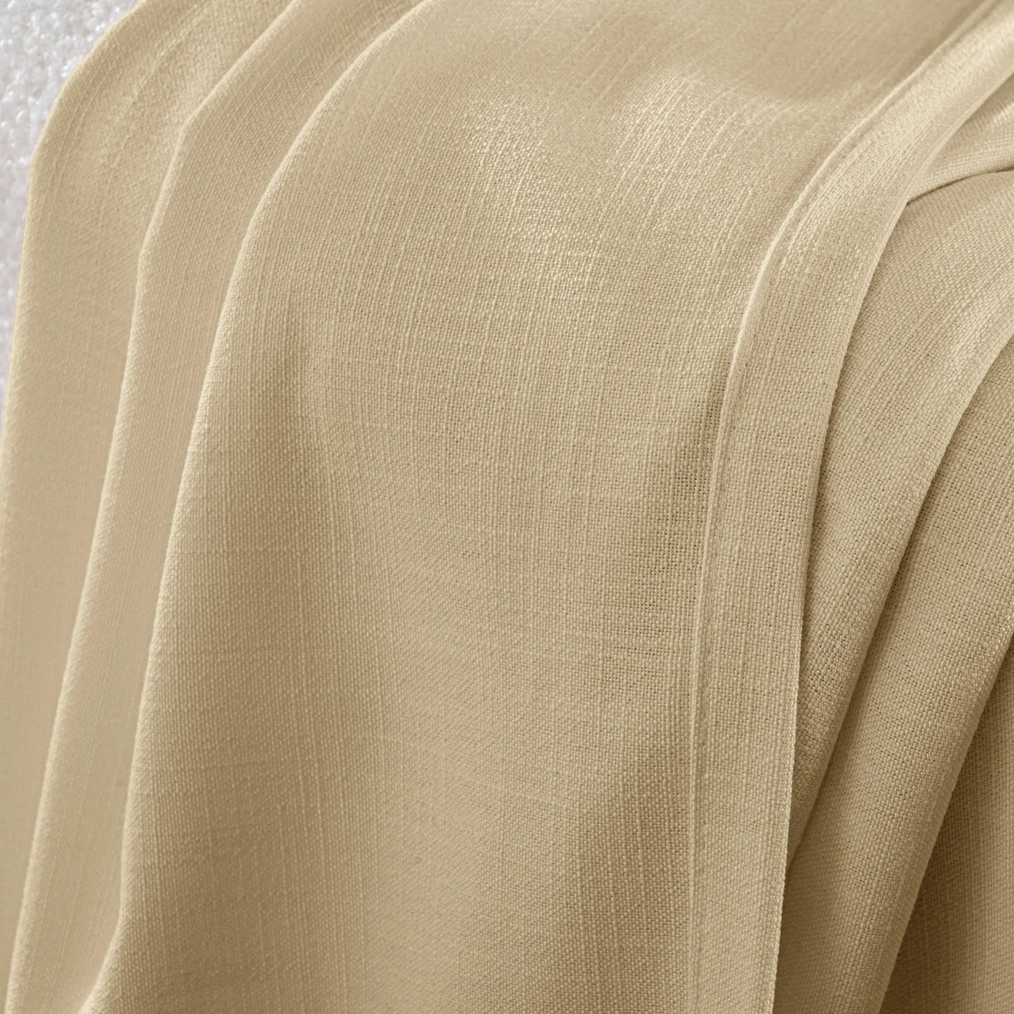 Detail of an honey flame-retardant polyester curtain with a slub-style texture and a thick, nubby weave pattern.