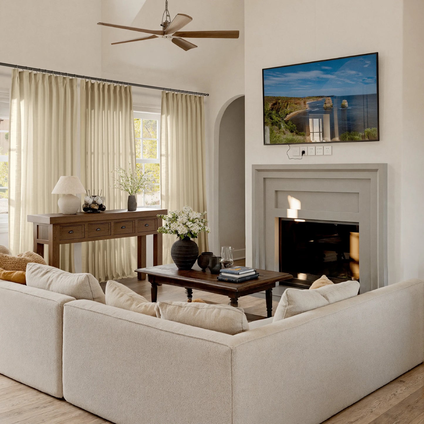 Living room with straw flame retardant curtains, beige sofa, coffee table, and TV mounted on the wall.