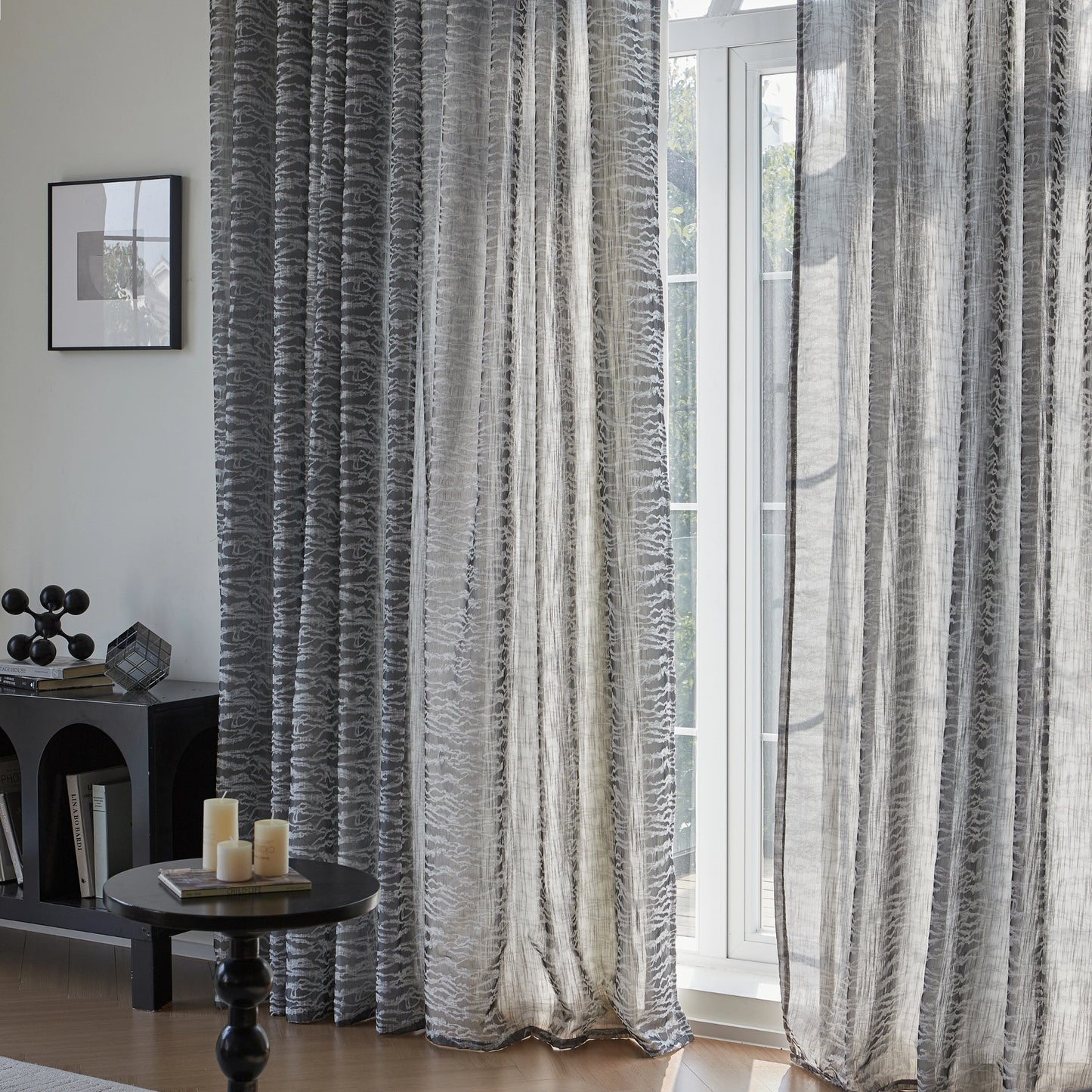 Textured stone-gray modern drapery in a room with a window showing a view of greenery.