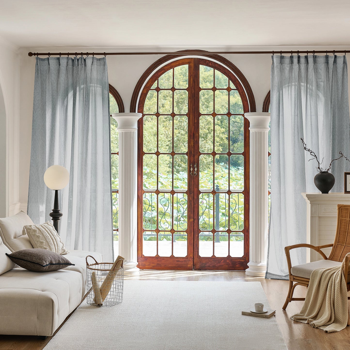 Living room with large arched window and gray curtains