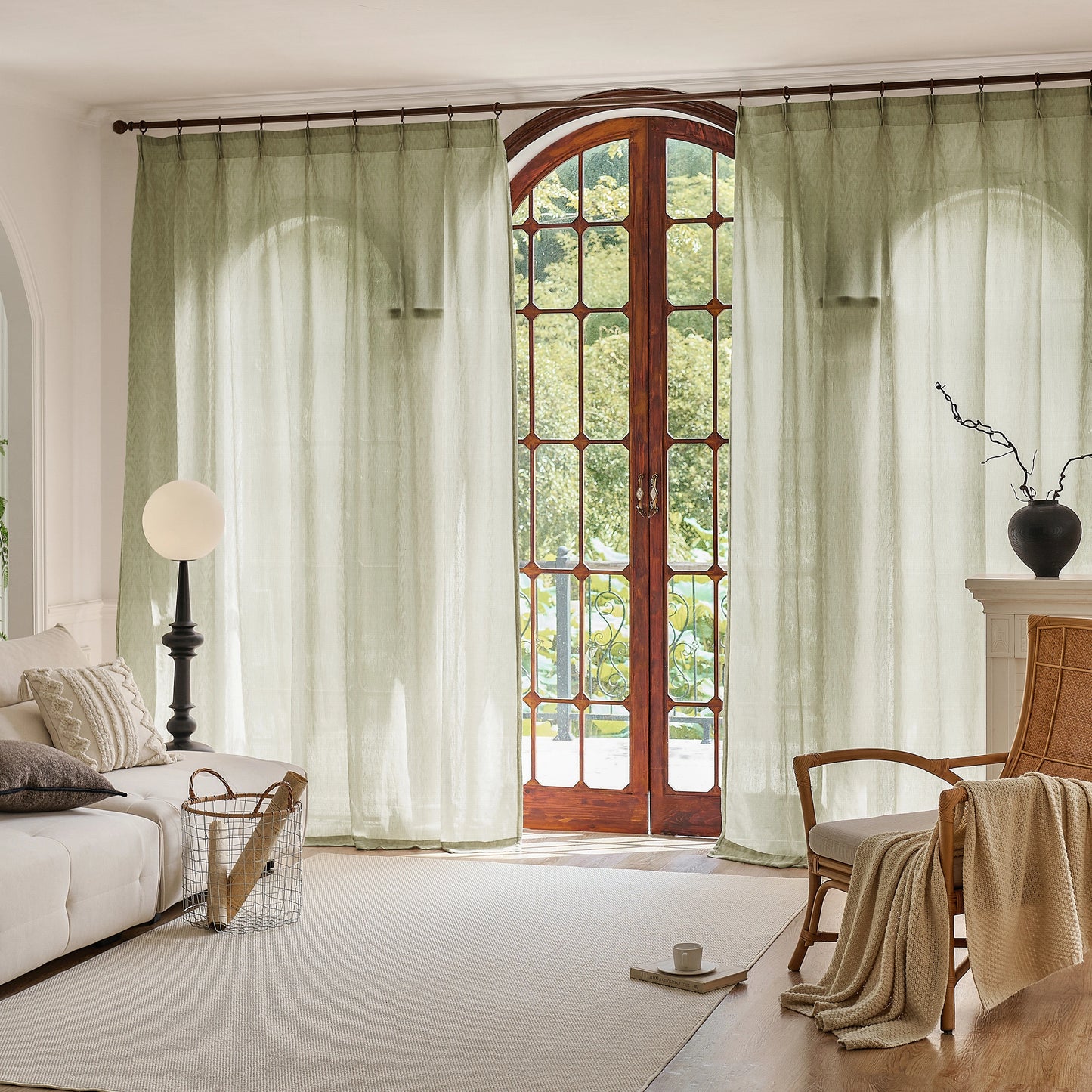 Living room with large windows, green sheer, and a wooden door.