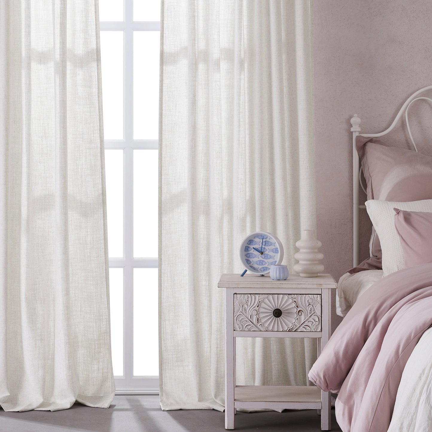 Bedroom with natural hemp polyester-linen combination drapery panels, a nightstand, and a bed with pink bedding.