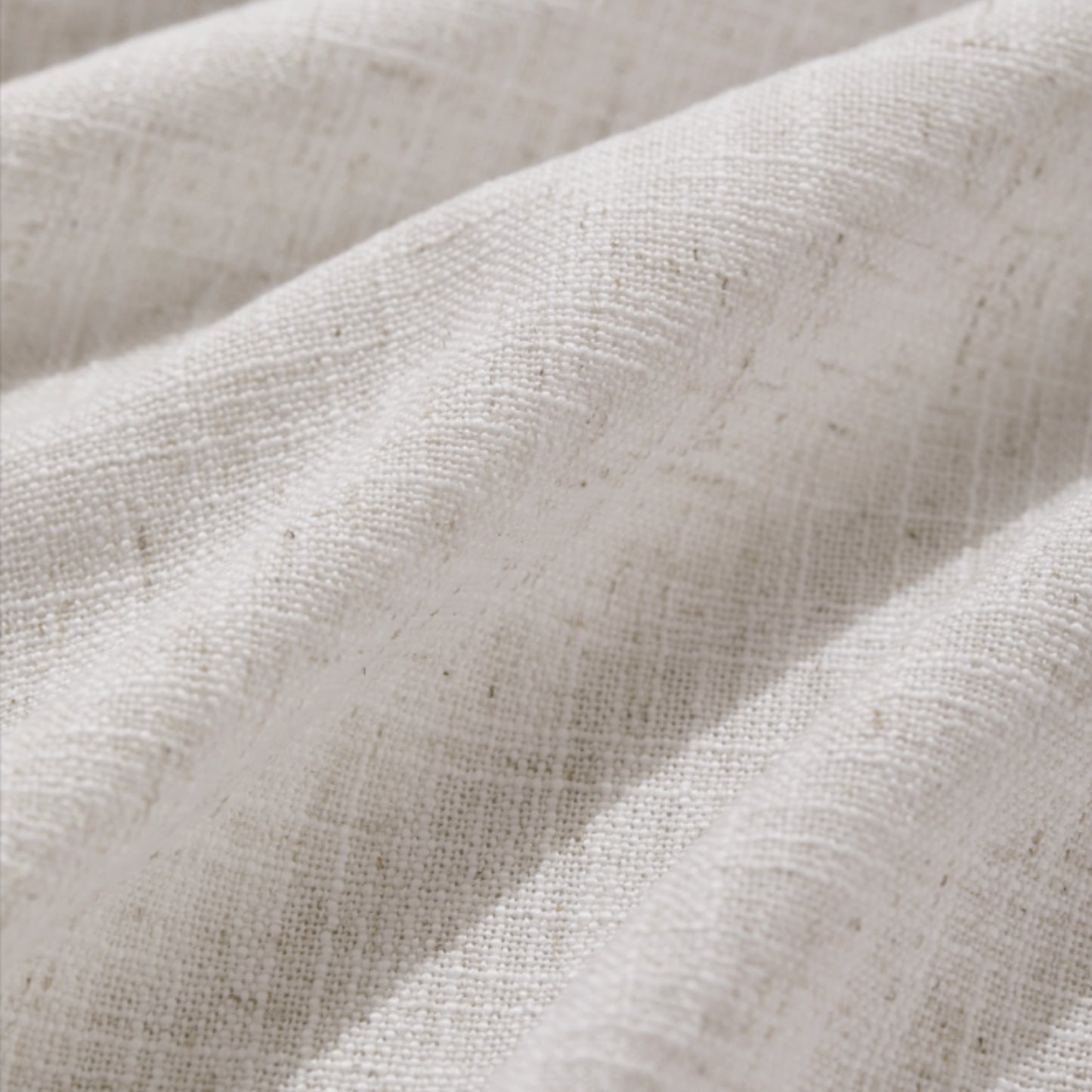 Detail of textured pale hemp polyester-linen woven curtains.
