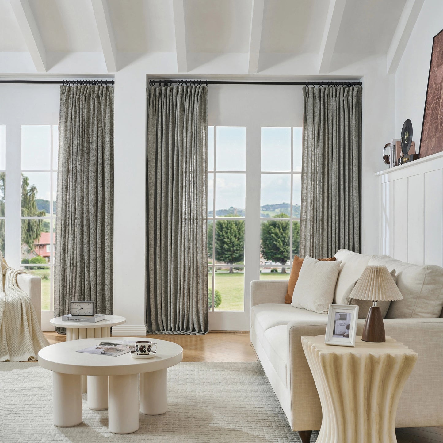 Modern living room with flax gray woven poly-viscose-linen curtains, sofa, and tables.