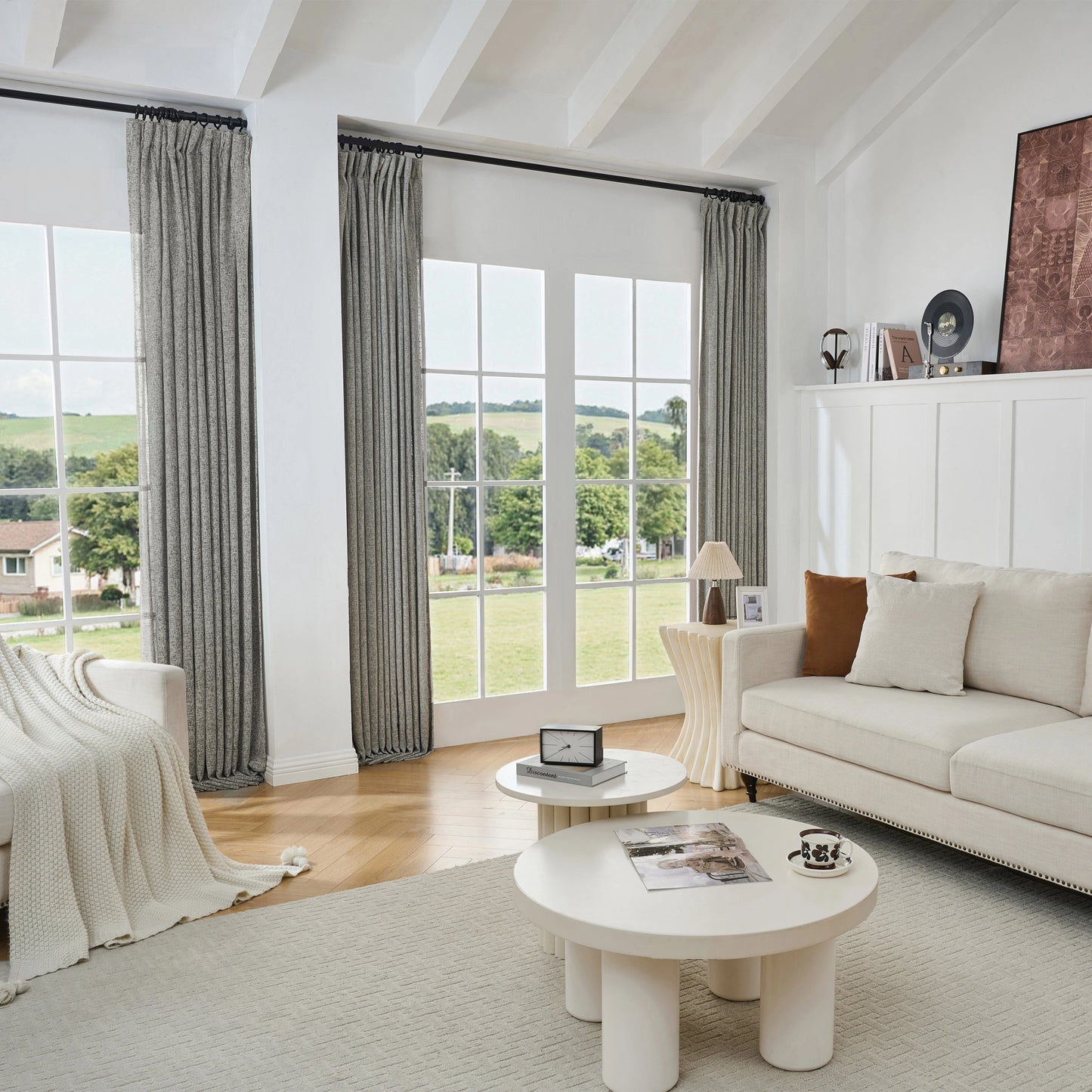 Living room with large windows, linen gray poly-viscose-linen drapery, and a white sofa.