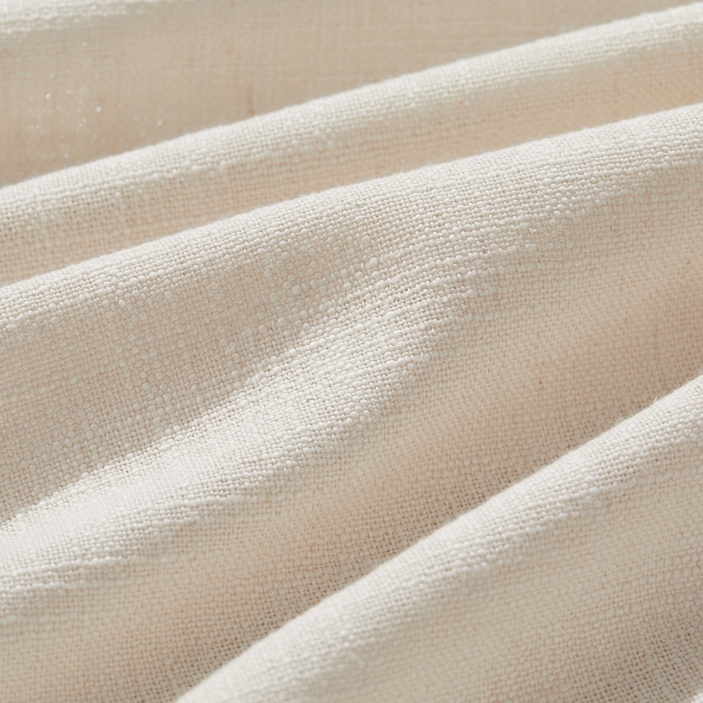 Detail of textured pale ivory polyester-linen woven curtains.