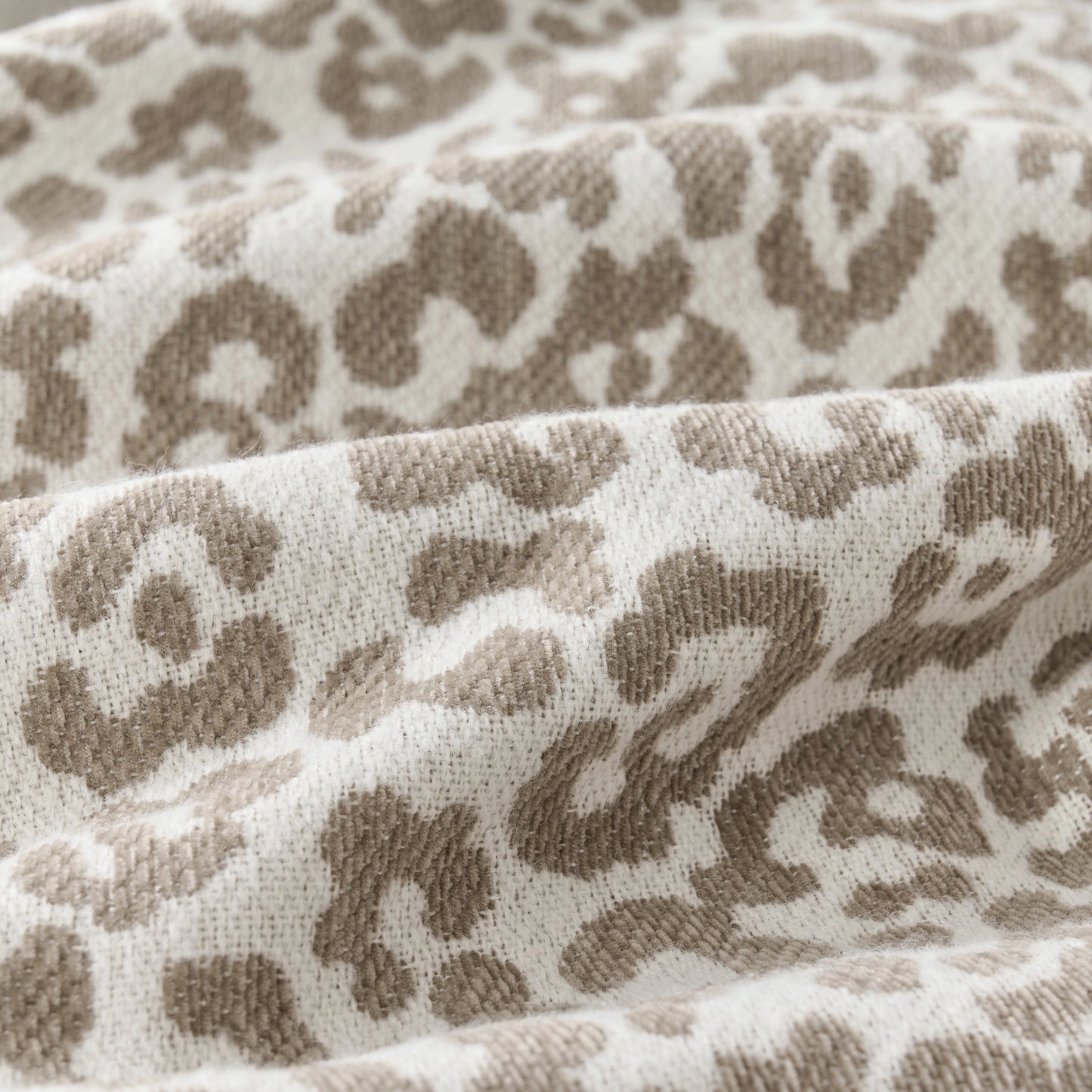Close-up of the textured fabric of a leopard-pattern modern curtain, highlighting the pattern details.