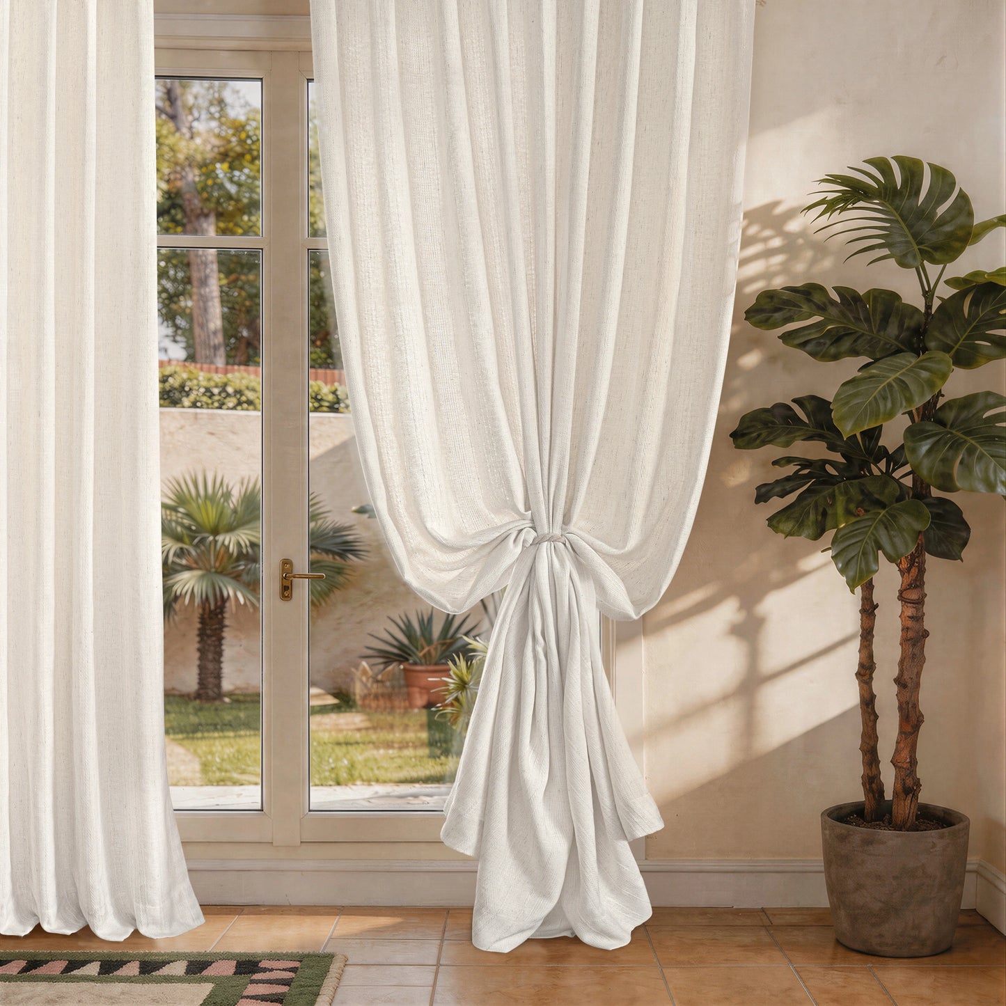Light filtering linen curtains tied back beside a sunlit window creating a soft and elegant look