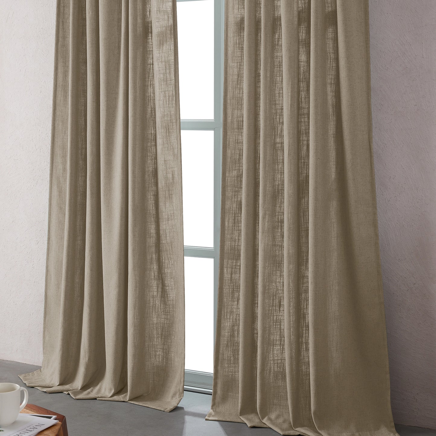Light camel linen-polyester blend curtains hanging in front of a window with a neutral background.