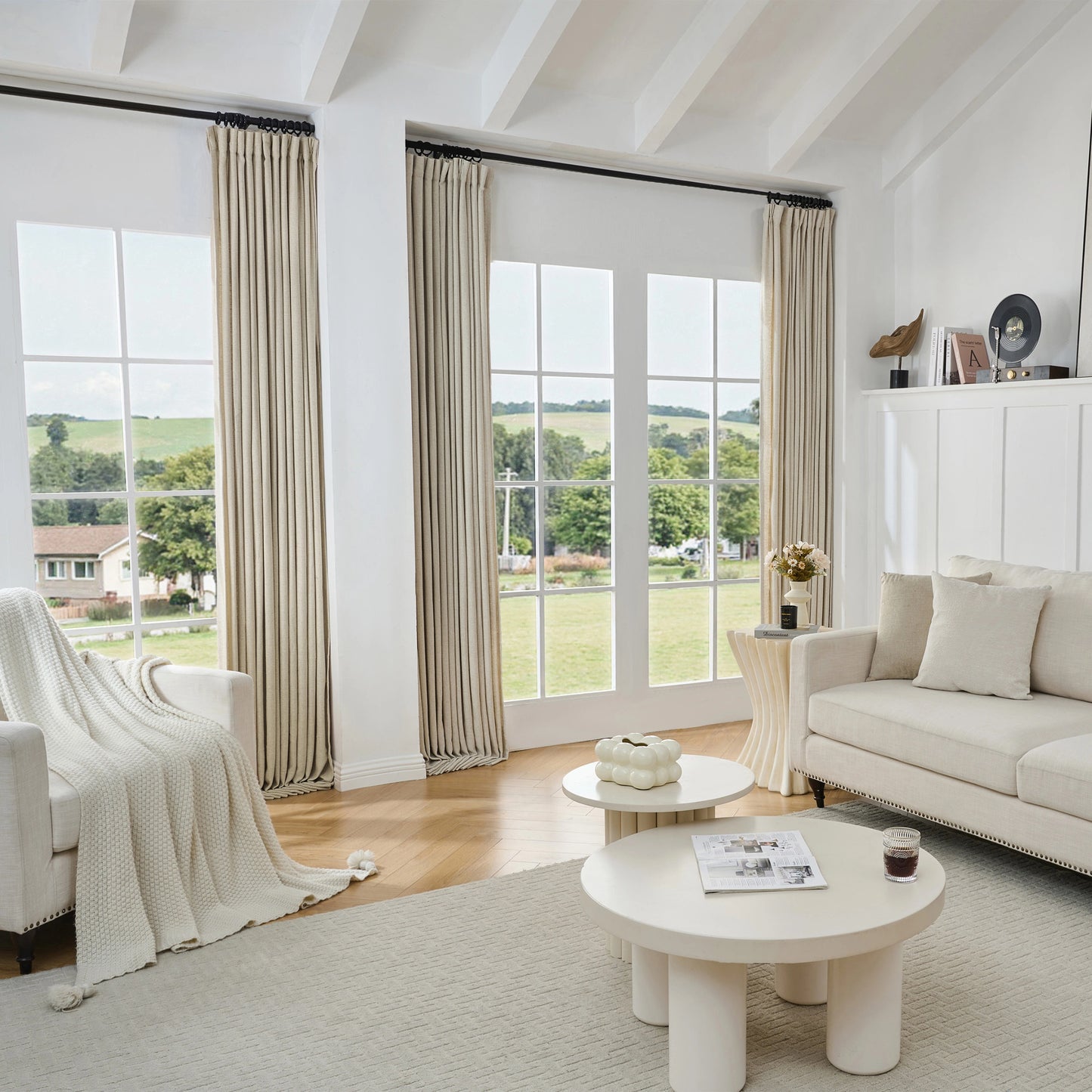 Living room with light camel viscose, polyester, and linen mixed fabric curtain, white sofa, and tables.