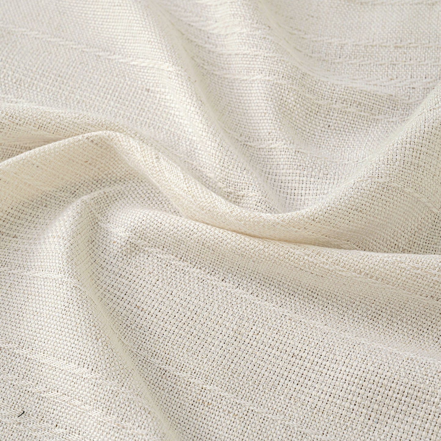 Close up of linen curtain fabric with soft folds and visible natural weave texture