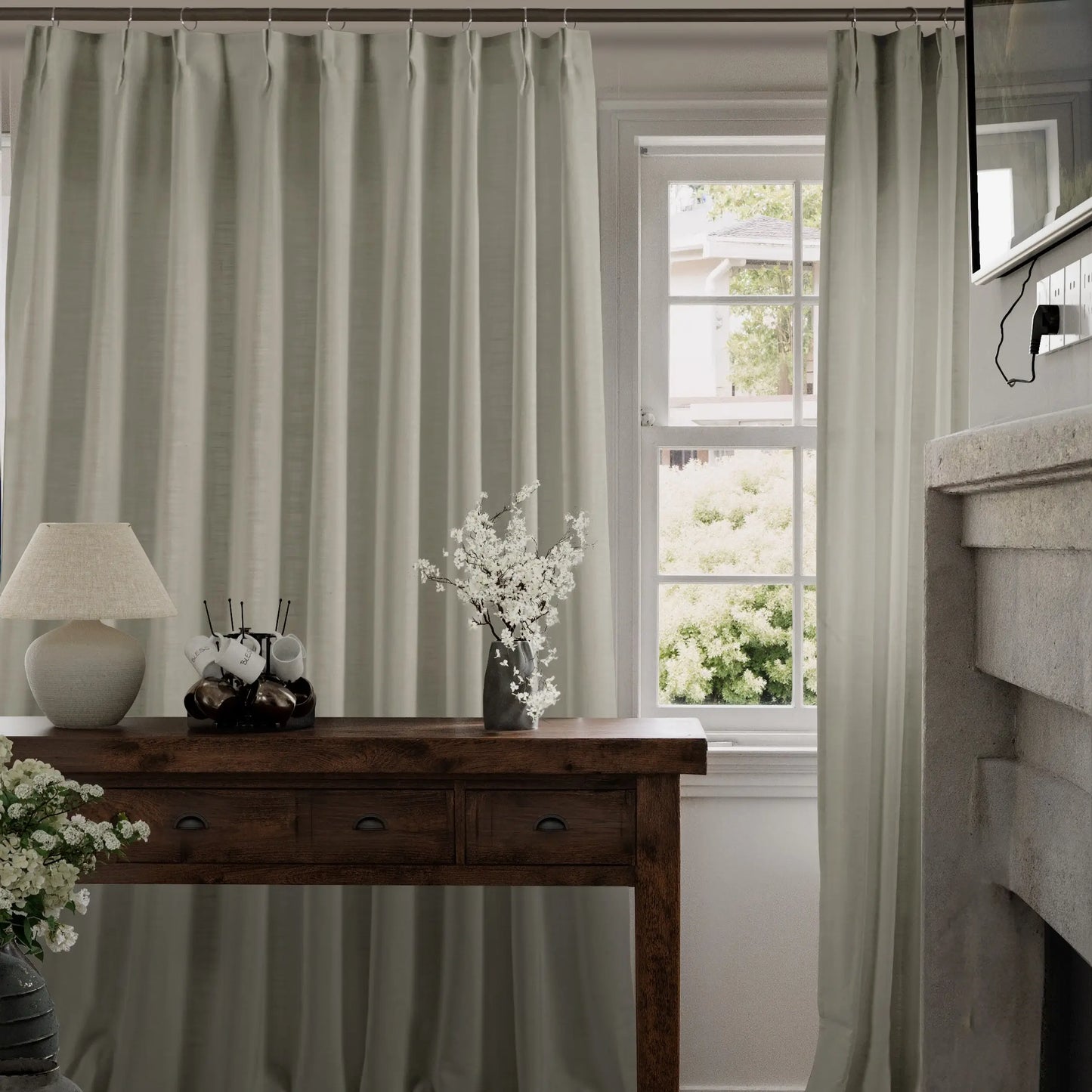 Driftwood curtains hanging in a room with a wooden console table and decorative items.