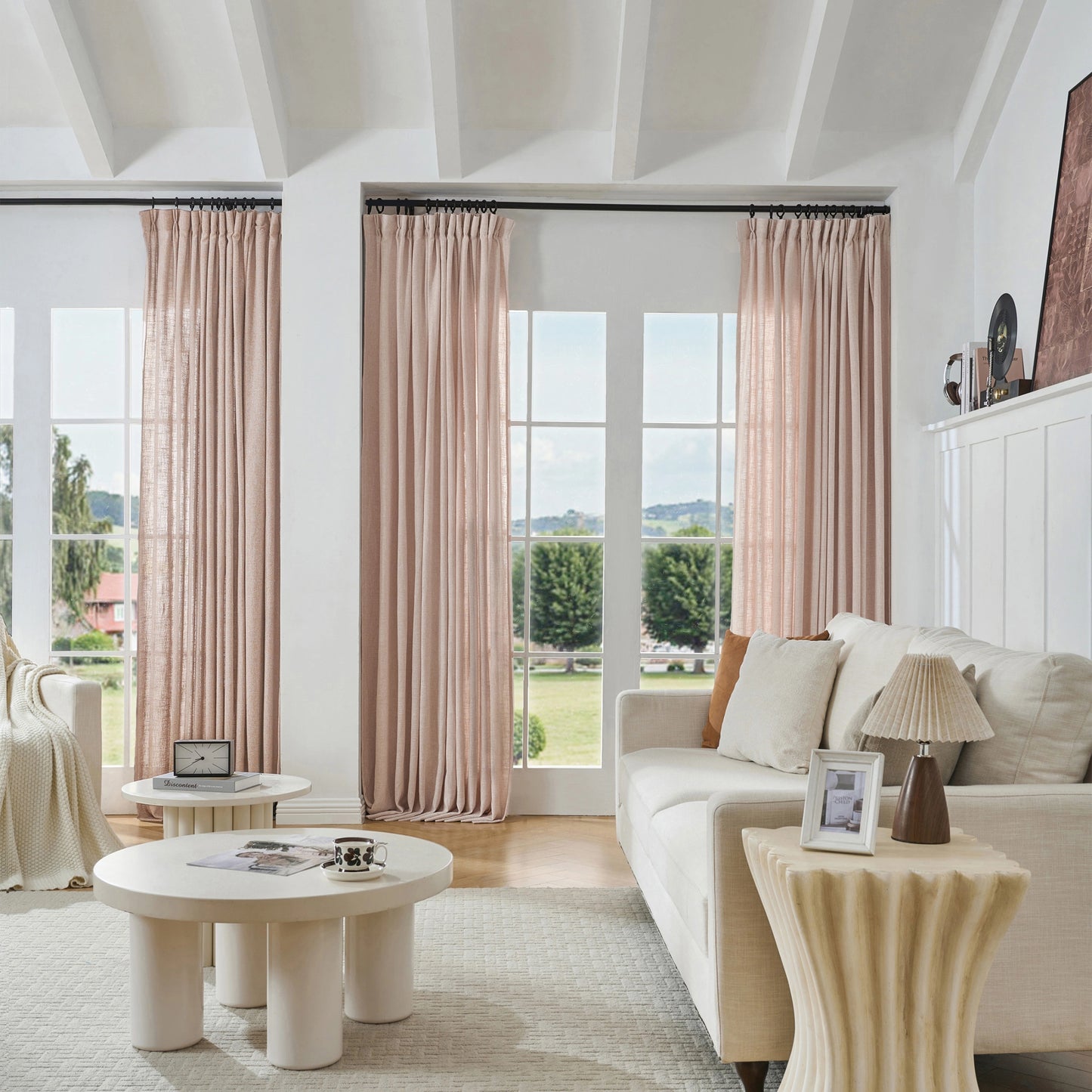 Modern living room with soft pink woven poly-viscose-linen curtains, sofa, and tables.