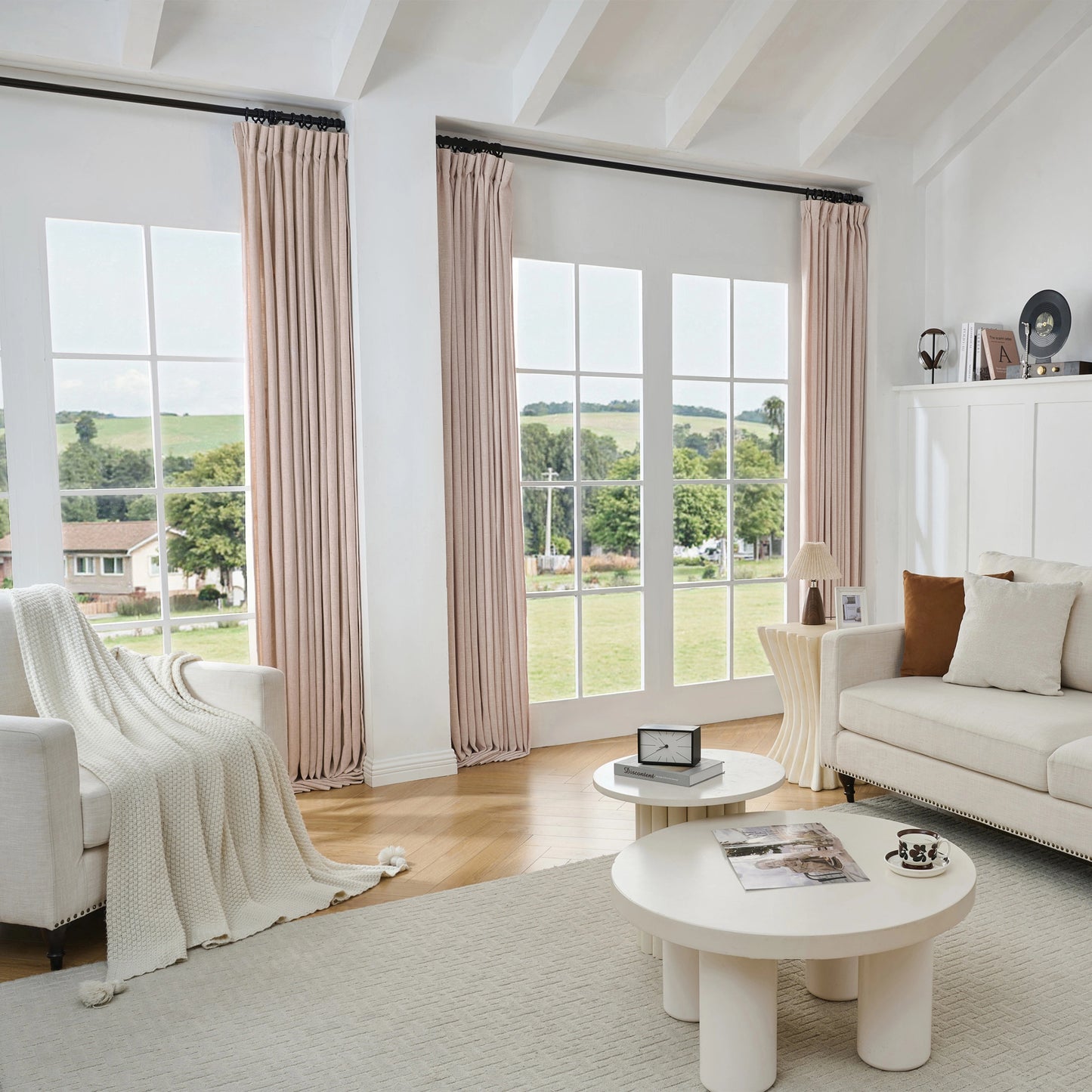 Living room with large windows, light pink poly-viscose-linen-drapery, and a white sofa.
