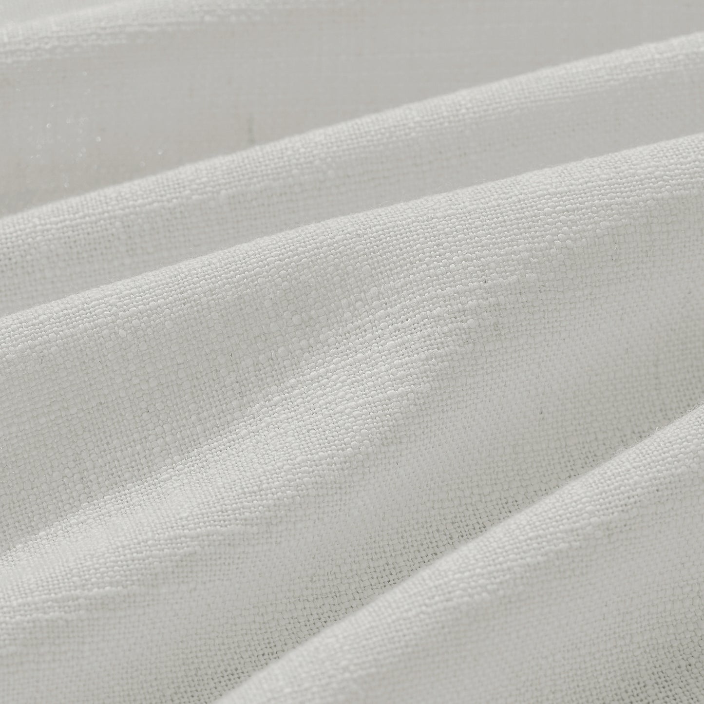 Detail of textured milky white polyester-linen woven curtains.
