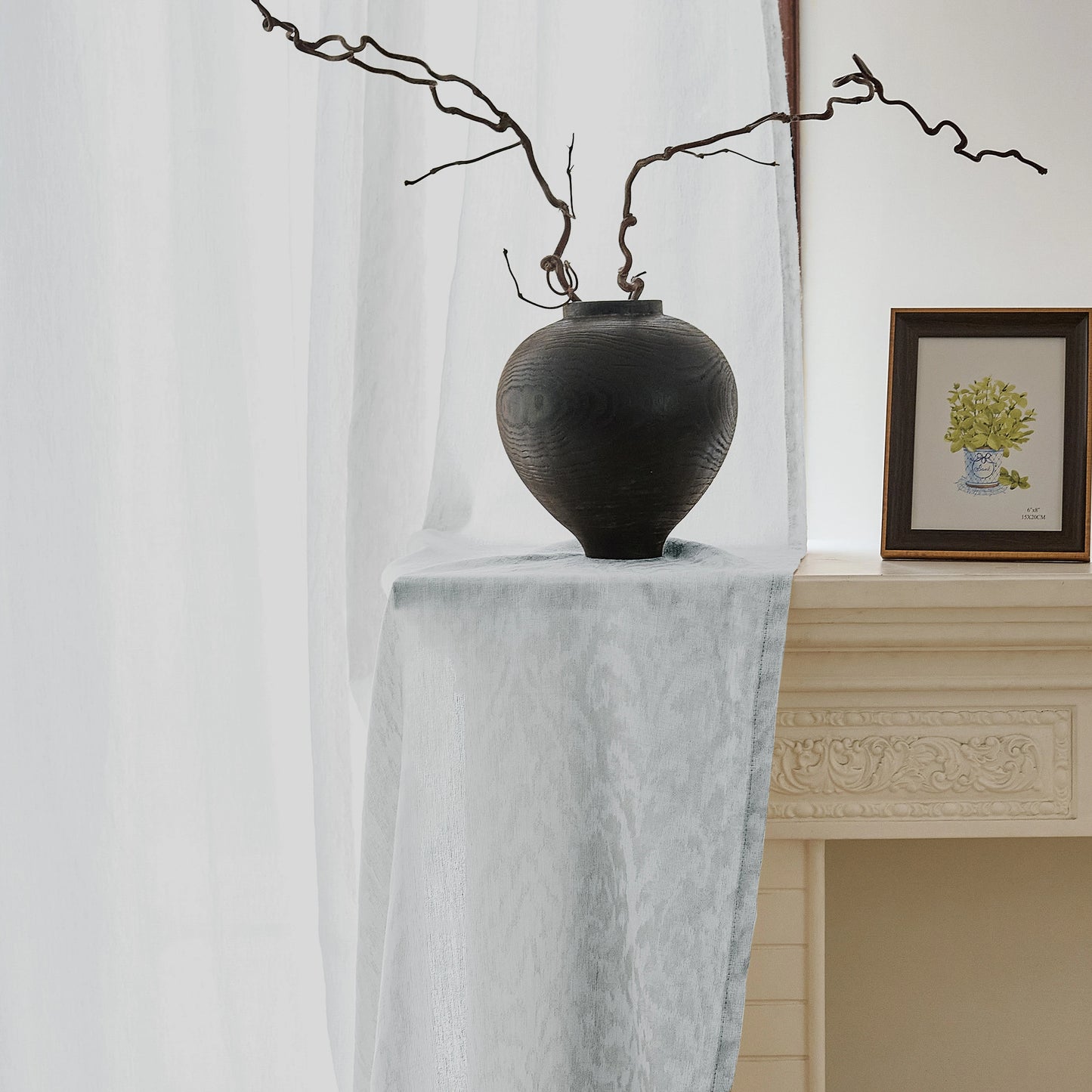 Close-up of a gray jacquard wool-blend sheer curtain showing delicate woven texture in natural light.