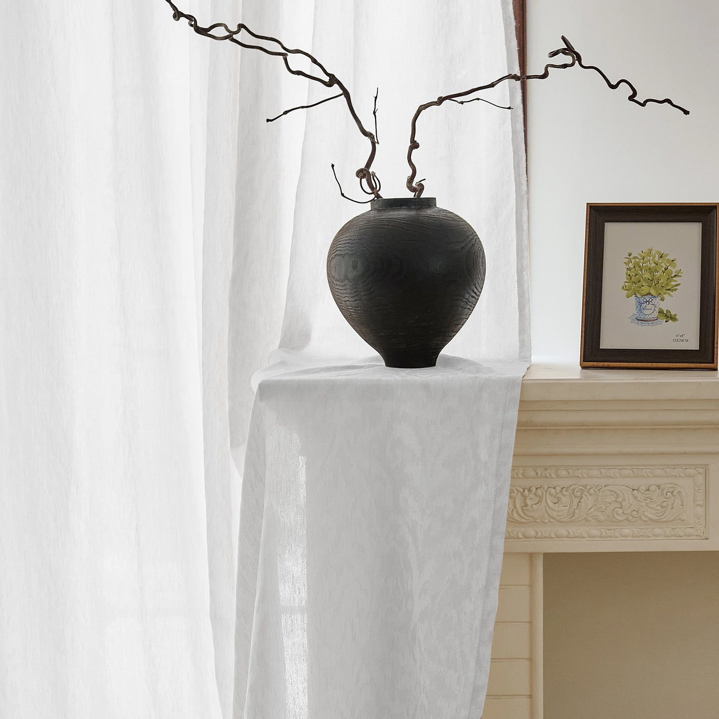 Textured white jacquard wool-blend sheer drapery creating a quiet, light-filled interior moment.