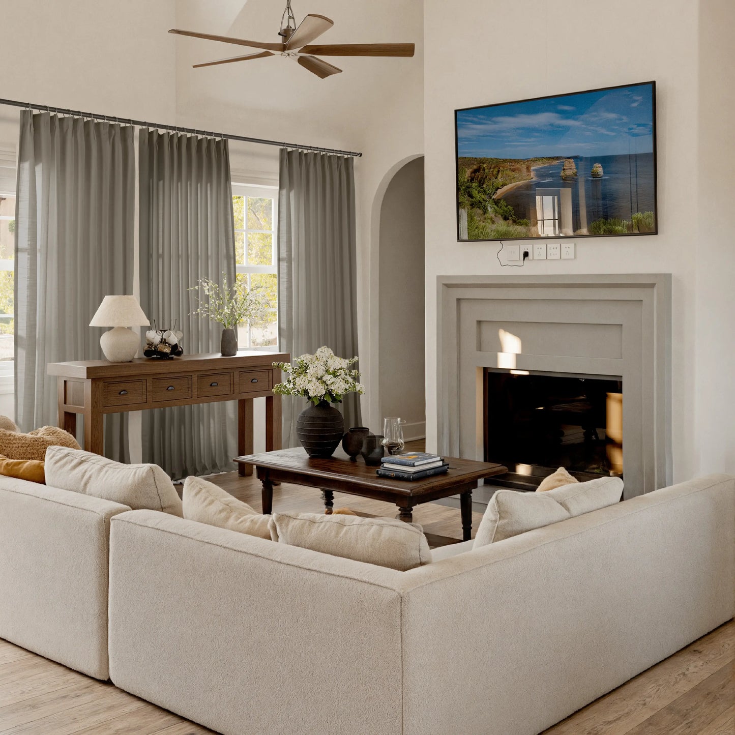 Modern living room with greige curtains, beige sofa, TV, and fireplace.