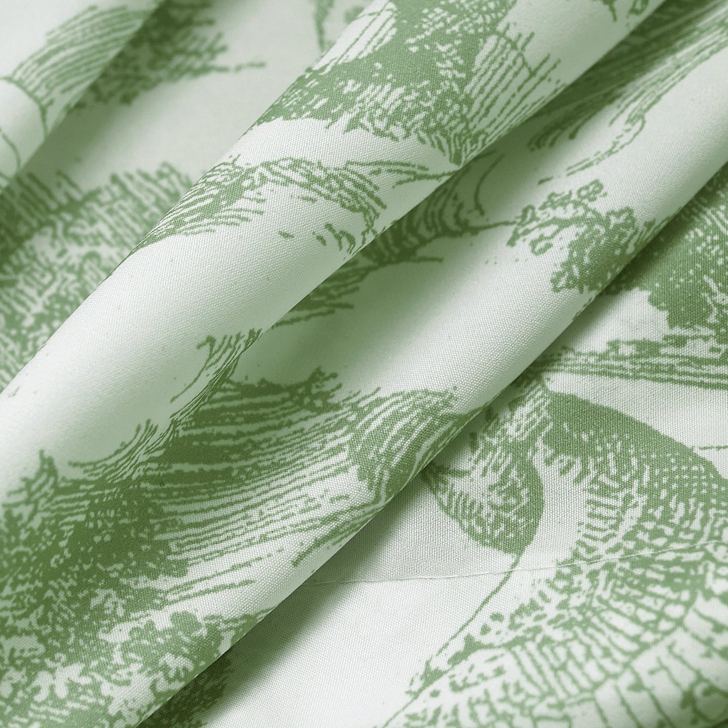 Close-up of green sheer curtain fabric with a delicate illustrated pattern and airy texture