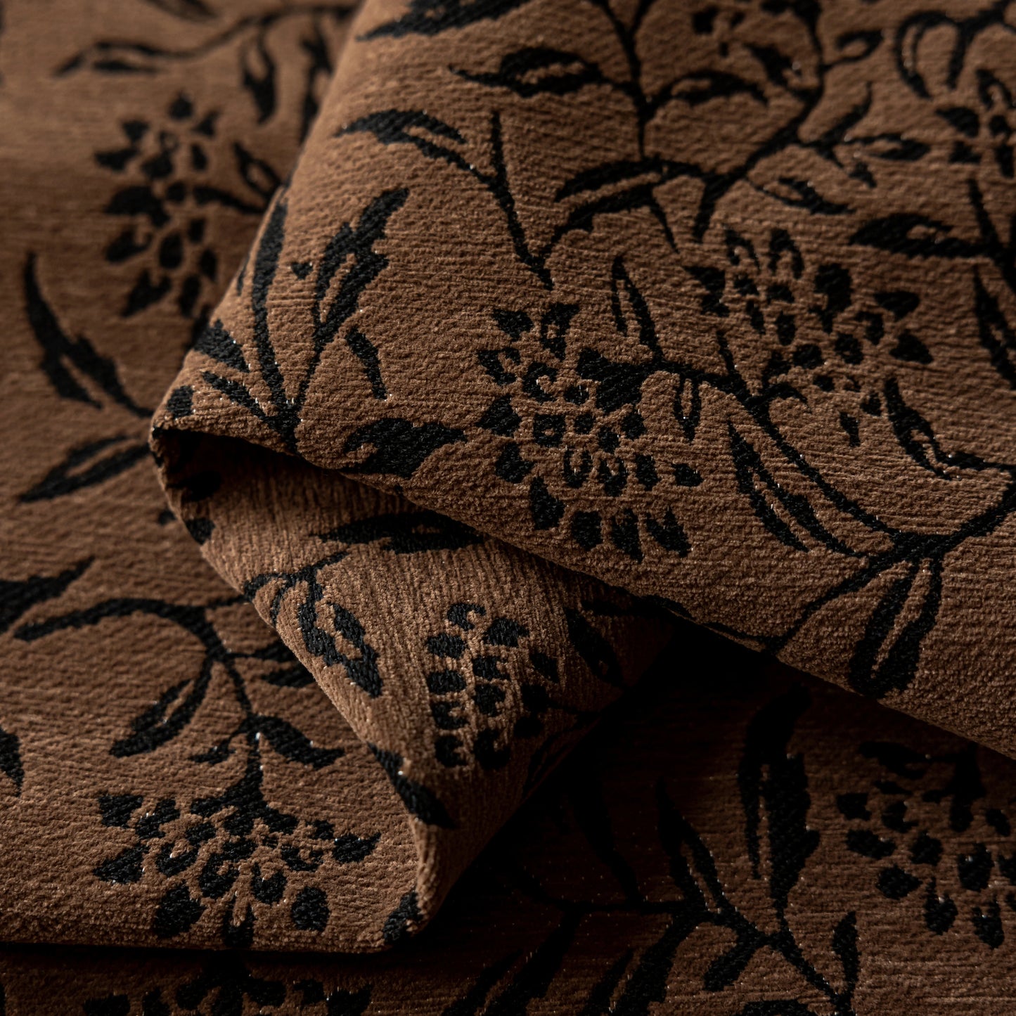 Detail view of a vintage cocoa curtain showcasing a charcoal flower motif.