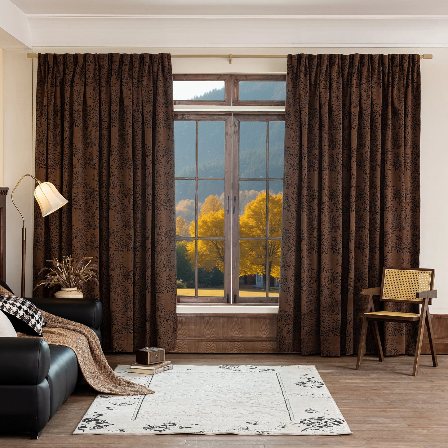 Living room with vintage brown curtains featuring black floral motif, a black sofa, and a chair.
