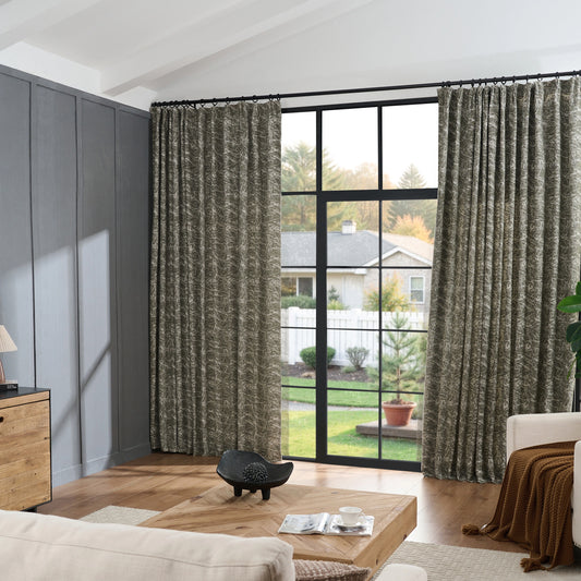 Living room with vintage jade curtains in sketched line pattern, wooden table and sofa placed in front.