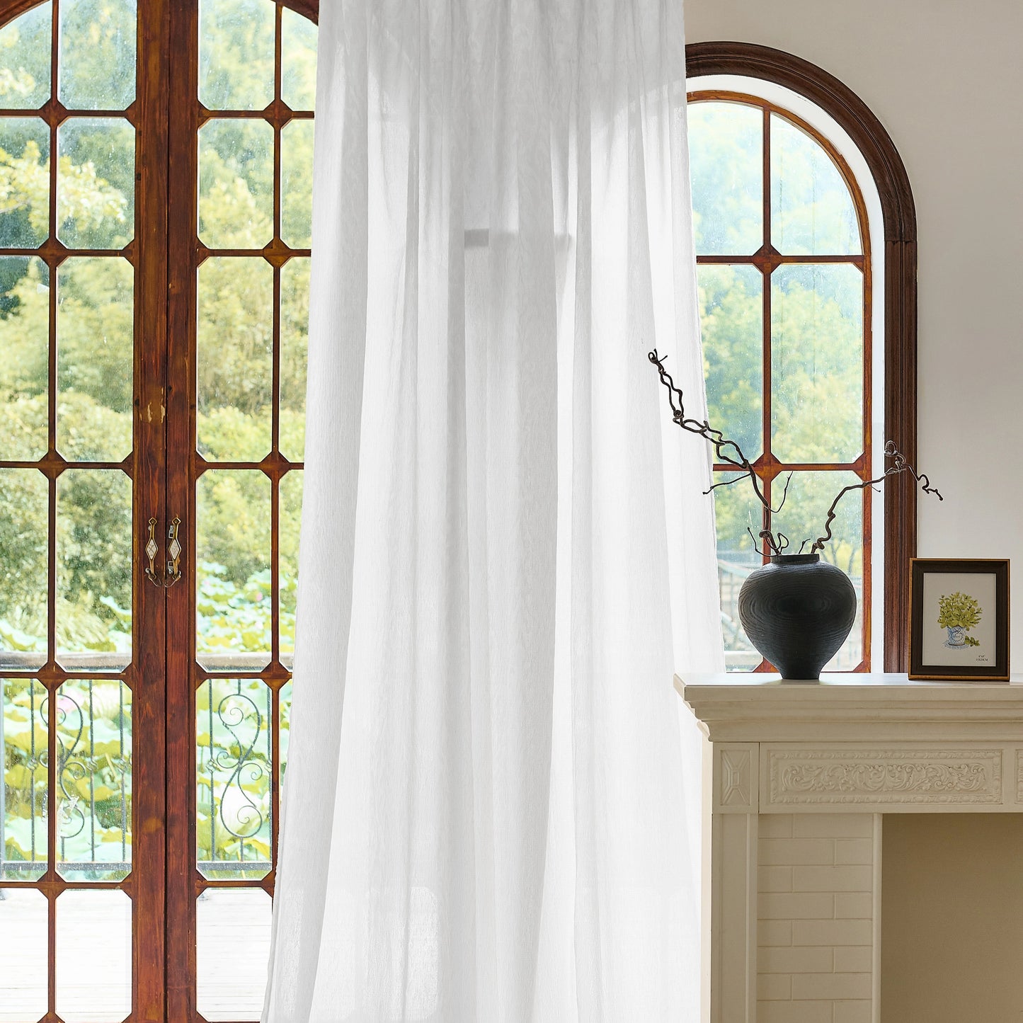 White wool-blend sheer curtains filtering natural daylight in a French-style living room with arched windows.