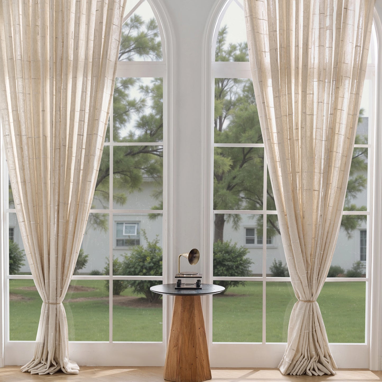 Oat curtains with a three-dimensional weave in a room with a small table and decor items.